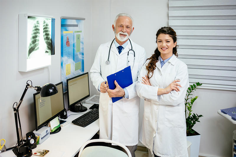 Two doctors standing together in bright office