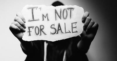 Person holding sign saying "I am not for sale"