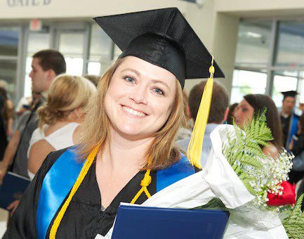 graduate holding her diploma and flowers