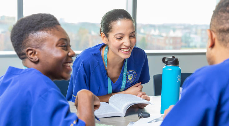 smiling nurses studying together at a table