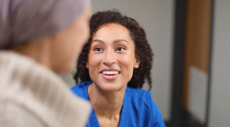 smiling nurse talking to an older patient
