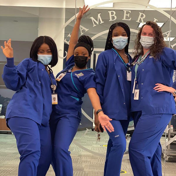 Masked nurses posing for a photo in front of the Chamberlain logo