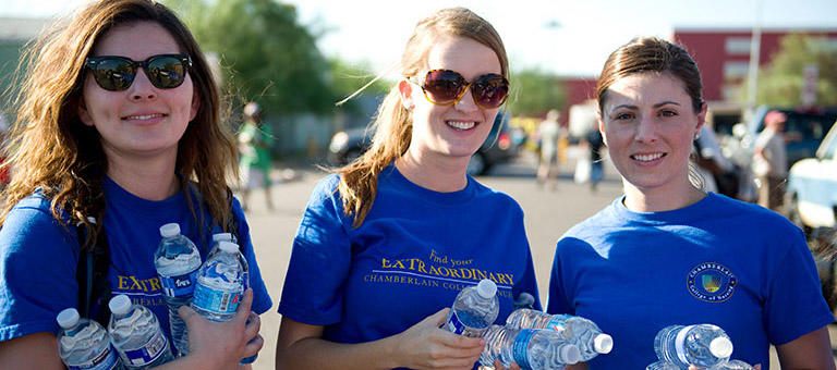 students at an event passing out water bottles